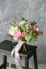 Spring bouquet of mixed flowers on vintage gray wall background behind