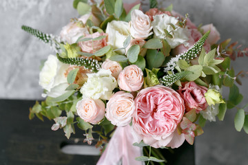 Spring bouquet of mixed flowers on vintage gray wall background behind