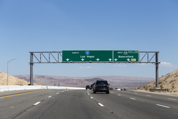 Interstate 15 Las Vegas freeway and highway 58 Bakersfield signs in the Mojave desert near Barstow,...