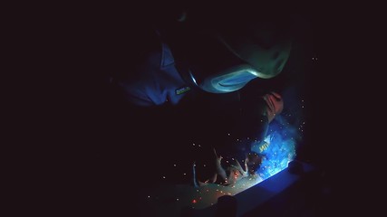 Professional semi automatic welding kit 380 volt and up to 300 ampere in super slow motion. Welder is working with protection mask at the metal construction factory. Heavy industry workshop - Powered by Adobe