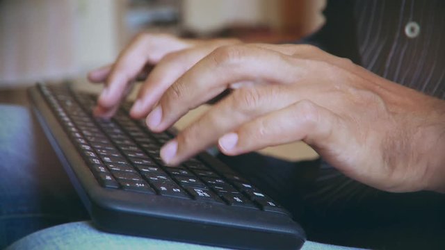man typing on the keyboard. hands of a young man close up