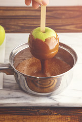 Dipping Homemade Caramel Apples in Hot Caramel