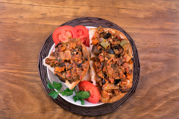 Sandwiches with stew of fried vegetables on white bread, tomato slices, parsley leaves.