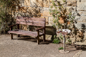 Wood bench & steel stool against brick wall