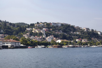 Fototapeta premium View of motorboats and yachts, Bosphorus, buildings in Kurucesme neighborhood on European side of Istanbul. It is a sunny summer day.