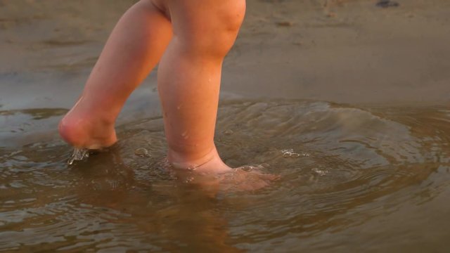legs of small child go on water. Slow motion. close-up.