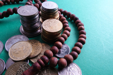 Islamic Banking/Financing Conceptual with rosary and coins on a green background. - 225246380