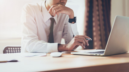 Businessman working on laptop at office room of design ideas. Vintage tone.
