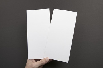 Mens hands holding white flyers