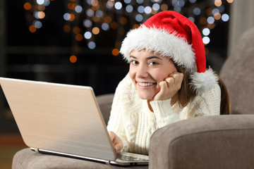 Teen using a laptop and looking at you in christmas