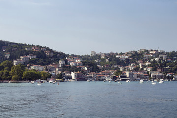 View of motorboats and yachts, buildings on European side and Bosphorus in Istanbul. It is a sunny summer day.