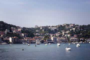 View of motorboats and yachts, buildings on European side and Bosphorus in Istanbul. It is a sunny summer day.