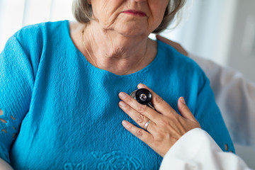 Fototapeta premium Female Doctor Checking The Heart With Stethoscope of Senior Adult Woman