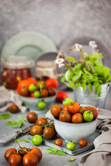 Fresh ripe cherry tomatoes in bowl on gray background
