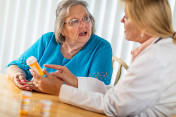 Female Doctor Talking with Senior Adult Woman About Medicine Prescription