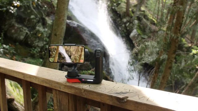 Phone gimbal recording a waterfall in the forest