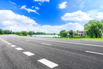 Fototapeta premium Asphalt highway and green forest natural scenery under the blue sky