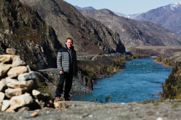 Man stands on the Katun river Bank in the Altai mountains, Russia.