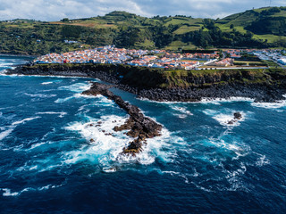 Flying over the ocean surf on the reefs coast in Maia city of San Miguel island, Azores, Portugal.