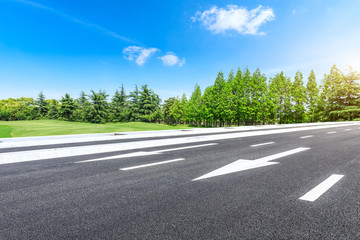 Fototapeta premium Asphalt highway and green forest natural scenery under the blue sky