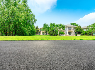 Empty asphalt road and forest with apartment buildings in the city suburbs