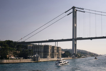 View of luxury yacht, Bosphorus bridge and old, historical mansion in Istanbul.