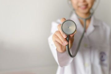Close up of female doctor standing and holding stethoscope for check patient with copy space