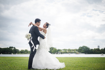 Happy smiling couple in wedding. Pretty Bride and handsome groom gorgeous posting in the nature.