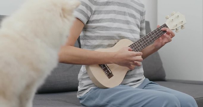 Woman play a song with Pomeranian dog
