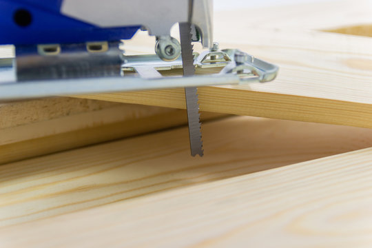Close-up electric sawing jigsaw with wood the start process of cutting the board