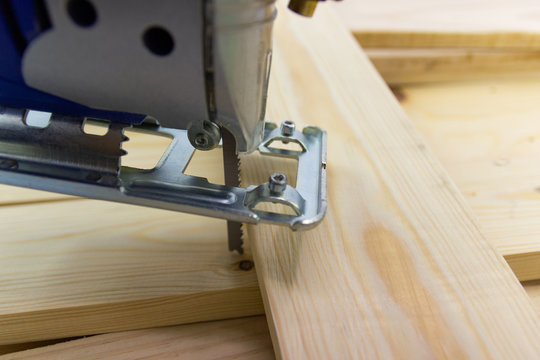 Close-up electric sawing jigsaw with wood the start process of cutting the board
