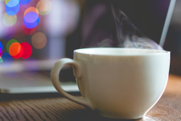 white classic cup with hot drink with steam come out on work place table  f