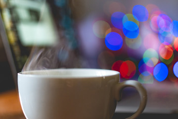 white classic cup with hot drink with steam come out on work place table  f