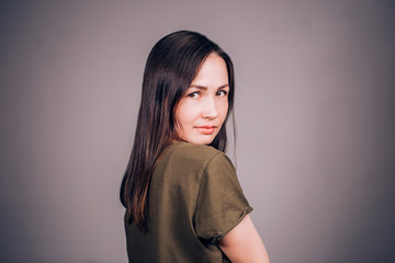 Woman on grey background with smile looking at camera