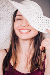 Beautiful woman in beige hat smiling charming smile, close up portrait