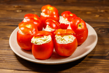 Tomatoes stuffed with cheese on wooden table