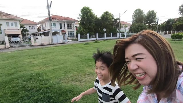 Asian mother and her son using a Action camera taking picture in the park