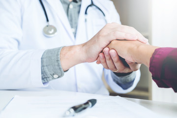 Doctor holding hands for comforting and care patient