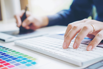 Graphic designer drawing on graphics tablet at workplace