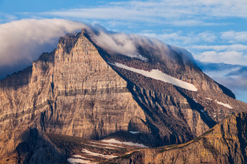 A blanket of clouds covers a mountain peak in Glacier National Park, Montana, USA