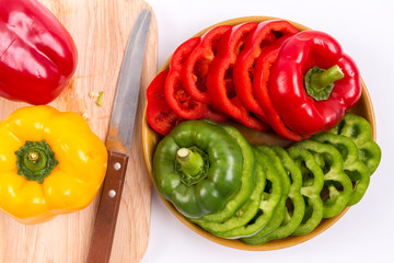 slices of red bell pepper and green bell pepper on isolated white background