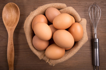 Fresh farm eggs on a wooden rustic background, Whipping eggs and whisk,top view with copy space