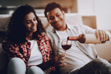 Afro American Couple Drinking Wine On A Couch.
