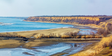 The panoramic landscape with the lowland river and the abrupt clay cliff on the shore. Don river, Rostov-on-Don region, Russia