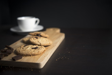 cookies and cup of coffee on the dark wood background 