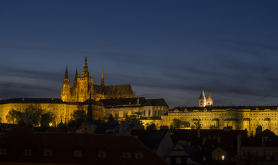 Fototapeta na wymiar Night view of illuminated St. Vitus Cathedral gothic churche and Prague Castle panorama with hradcany, dark blue sky.
