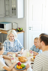 Young modern family in casualwear having talk by breakfast in the morning