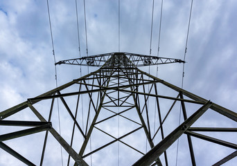 power transmission line pylons with threatening dark clouds background