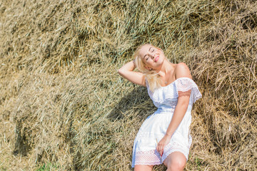 Freedom concept. Young happy woman in hay, evening light. Beauty Girl Outdoors enjoying nature....