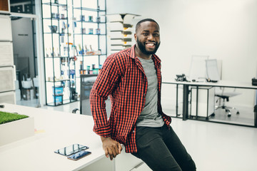 African American man  smile with phone in design studio. 